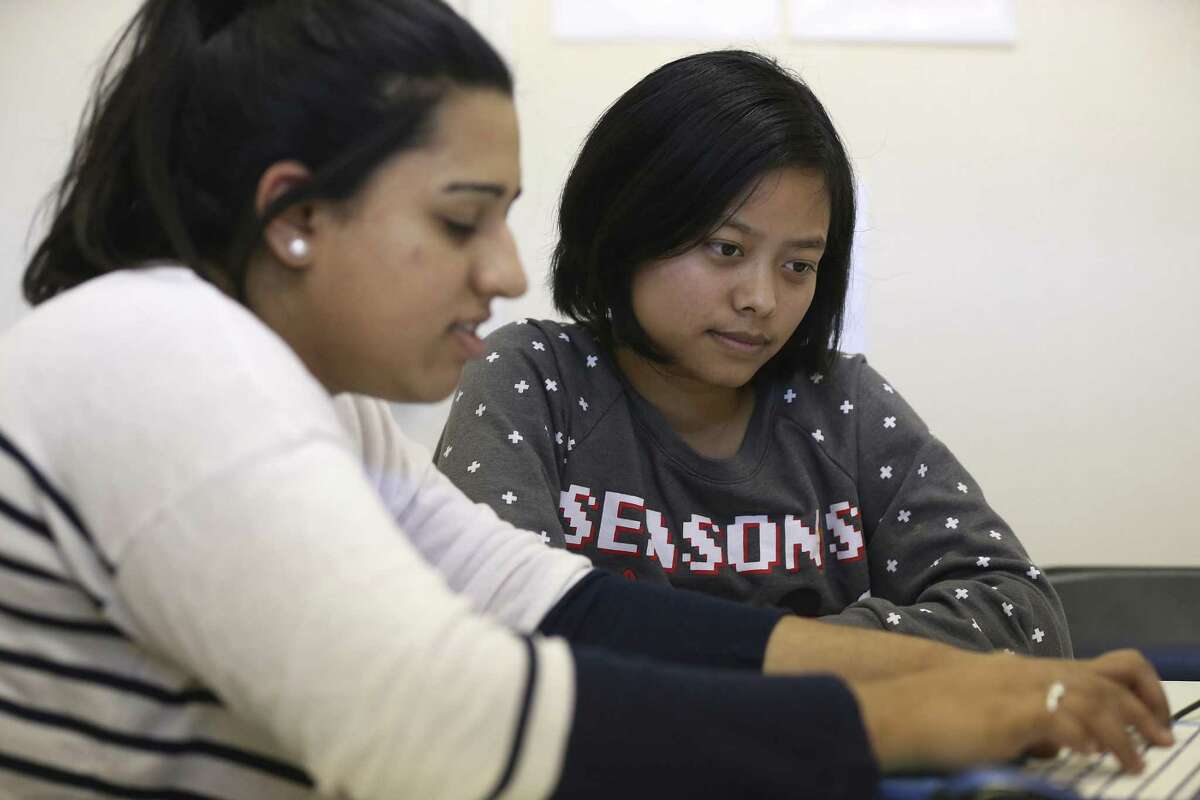 Volunteer Kiran Lalani, 20, left, helps Lun Nuam, 23, with a history assignment during and English as a Second Language class at The Center for Refugee Services, Thursday, Jan. 19, 2017. Nuam is an immigrant from Myanmar and has been in the U.S. three years.