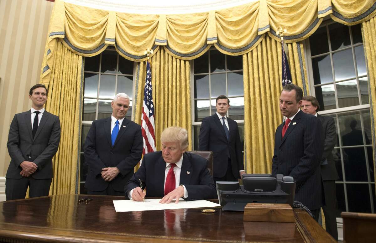 President Donald Trump prepares to sign a confirmation for Homeland Security Secretary James Kelly, in the Oval Office at the White House in Washington, D.C. on January 20, 2017.
