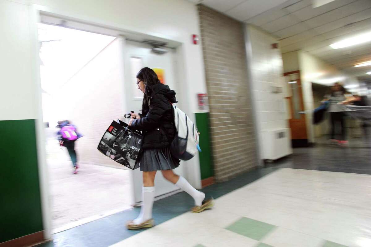 A student leaves Trinity Catholic Middle School to catch the bus in Stamford, Conn. on Monday, Jan. 23, 2017.