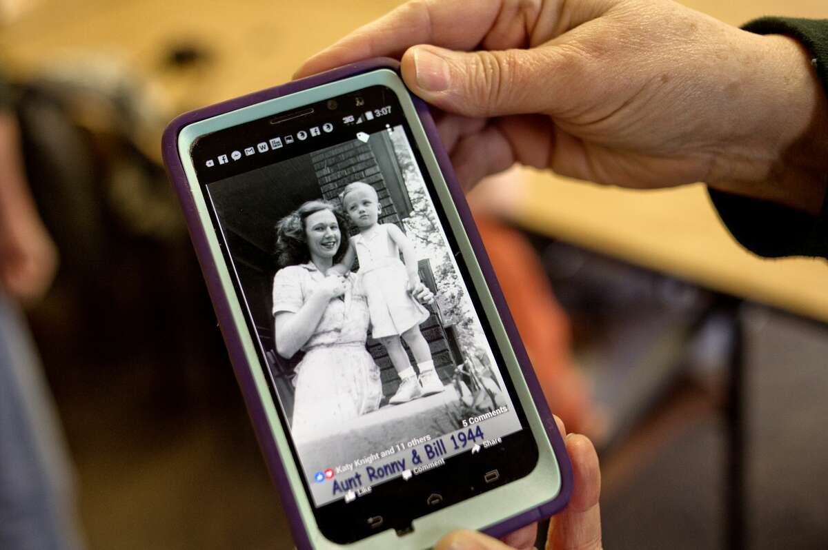 Gerianne Dent shows a 1944 picture of Veronica Schmidt and Gerianne's husband's brother, Bill, from her phone on during Veronica's 100th birthday party Monday at Pinecrest Farms.