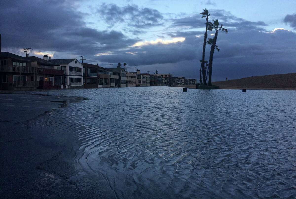 Water gathers along beach front property in Seal Beach, Calif. on Monday, Jan. 23, 2017. The tail end of a punishing winter storm system lashed California with thunderstorms and severe winds Monday after breaking rainfall records, washing out roads and whipping up enormous waves. At least four people died and several others were rescued from raging floodwaters during three storms in four days. (AP Photo/Amy Taxin)