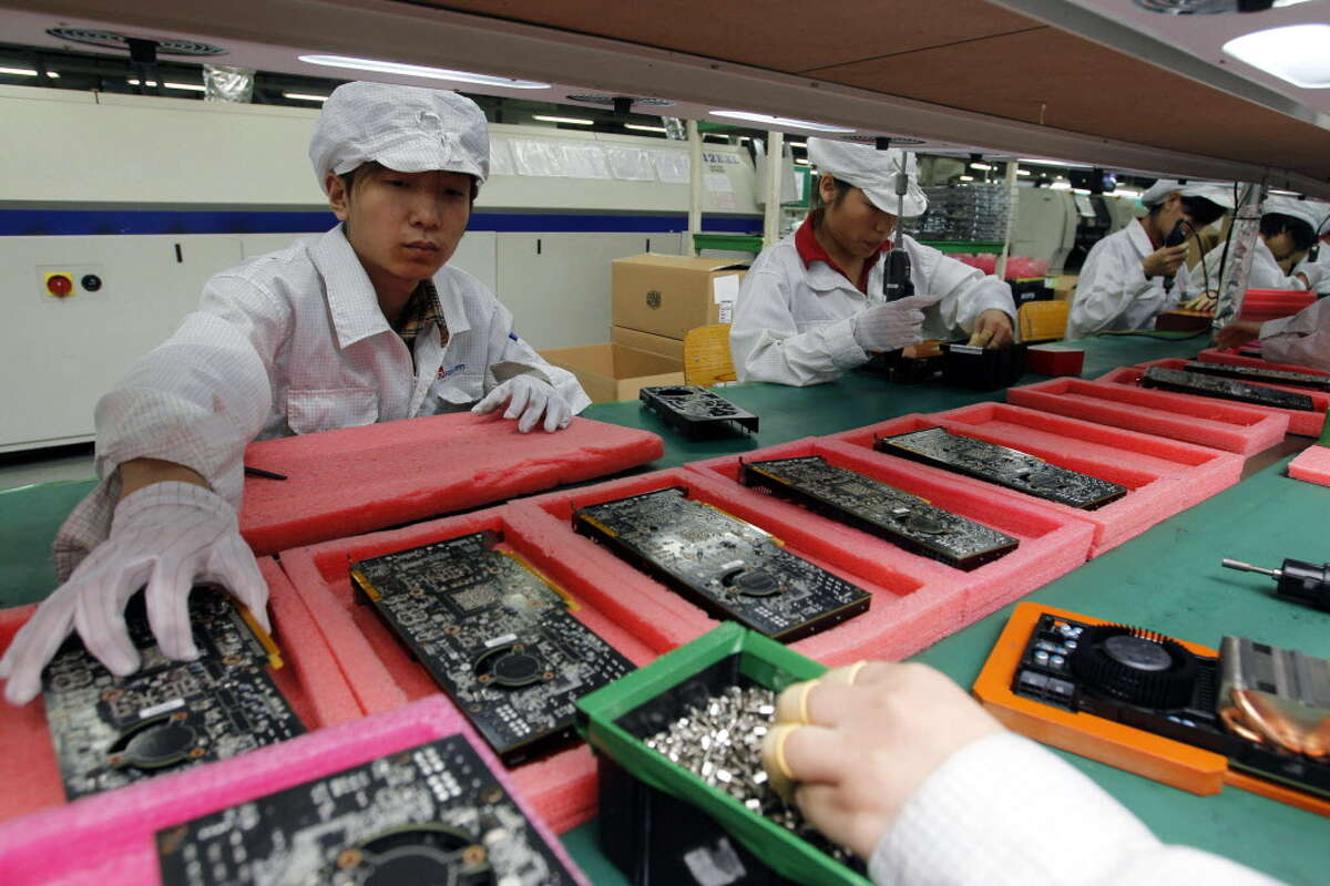 FILE - In this May 26, 2010 file photo, staff members work on the production line at the Foxconn complex in the southern Chinese city of Shenzhen. The company that makes AppleAA?’s iPhones suspended production at a factory in China on Monday, Sept. 24, 2012, after a brawl by as many as 2,000 employees at a dormitory injured 40 people. The fight, the cause of which was under investigation, erupted Sunday night at a privately managed dormitory near a Foxconn Technology Group factory in the northern city of Taiyuan, the company and Chinese police said. (AP Photo/Kin Cheung, File)