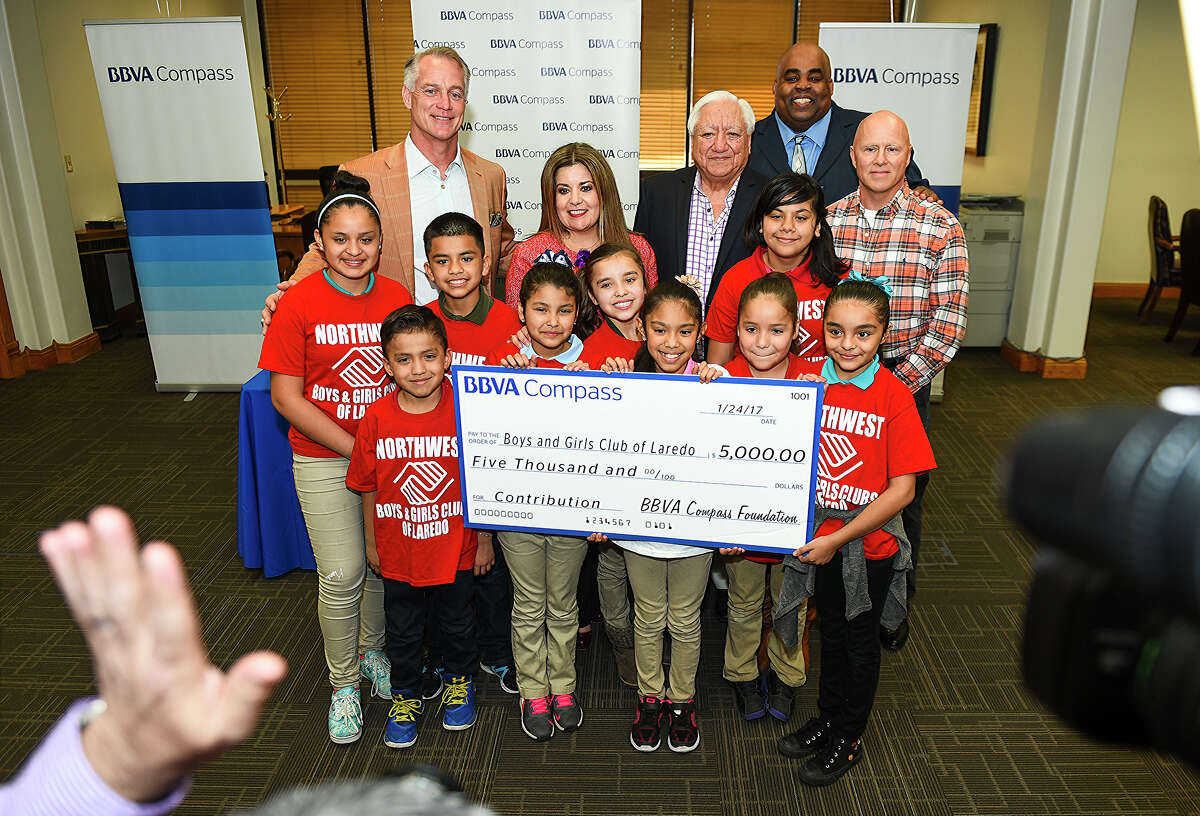 Former Dallas Cowboys player Daryl Johnston, BBVA Compass City President Susana Valencia, Boys and Girls Club of Laredo Hector J. Noyola, L.I.S.D. Superintendent Dr. A. Marcus Nelson, Boys and Girls Club of Laredo Board President Jim Kelly and children from the club pose for a photo on Tuesday, January 24, 2017 at the BBVA Compass University Branch as the bank donates $5,000 to the Boys and Girls Club of Laredo.