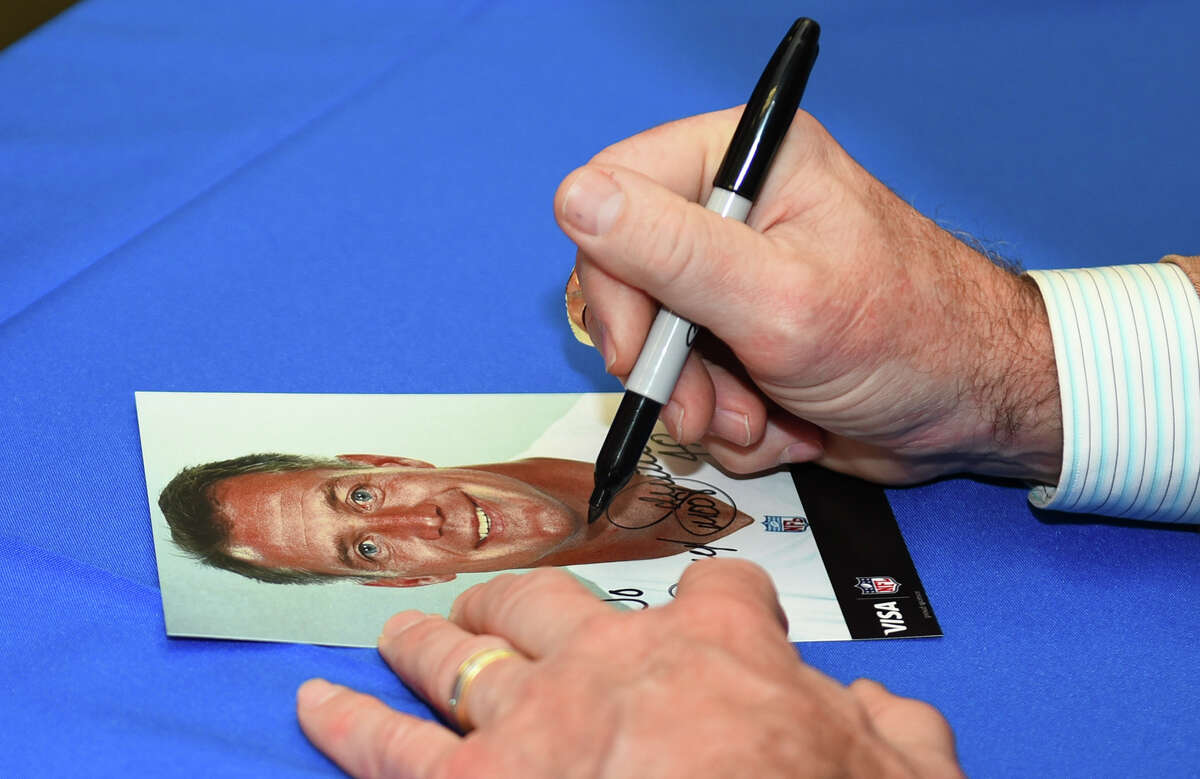 Former Dallas Cowboys player Daryl Johnston autographs a headshot of himself on Tuesday, January 24, 2017 at the BBVA Compass University Branch during a meet and greet session.