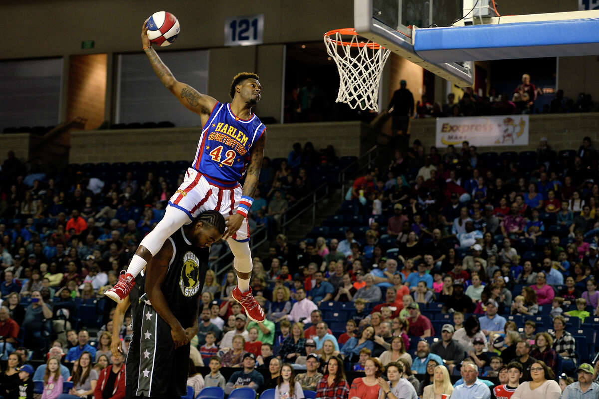 Harlem Globetrotter Angelo "Spider" Sharpless dunks over a player from the World All-Stars during their performance at Ford Arena on Tuesday night. Photo taken Tuesday 1/24/17 Ryan Pelham/The Enterprise