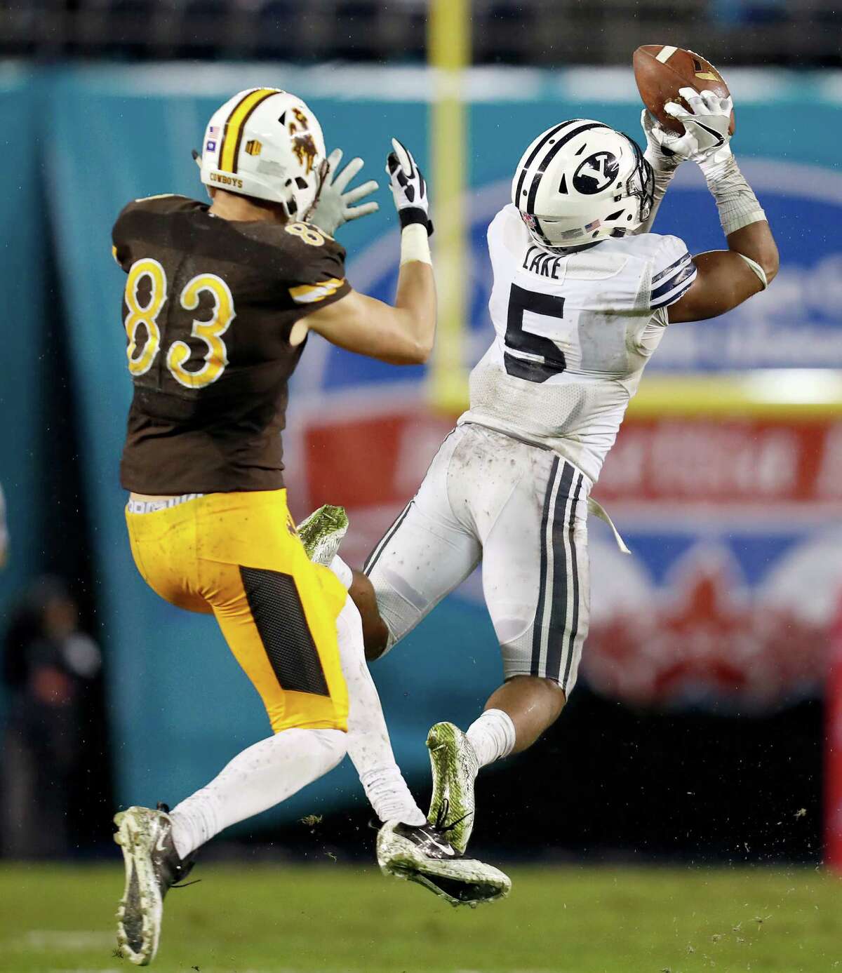 BYU defensive back Dayan Lake, right, intercepts the football in front of Wyoming wide receiver Jake Maulhardt, left, on a pass by quarterback Josh Allen during the first half of the Poinsettia Bowl NCAA college football game Wednesday, Dec. 21, 2016, in San Diego. (AP Photo/Ryan Kang)