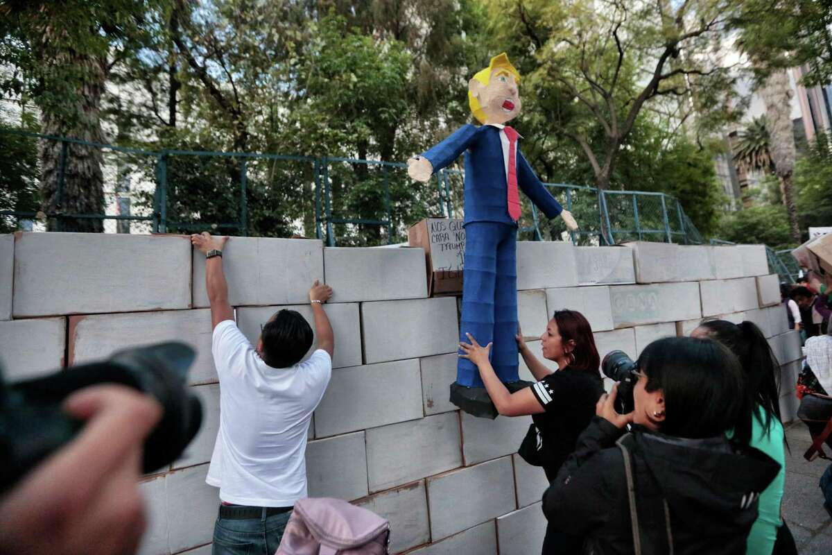 People protest against U.S. President Donald Trump’s inauguration next to a fake wall with a dummy representing him in Mexico City last week. If Trump proceeds with plans for a border wall, this will unnecessarily sour relations with a valued ally.