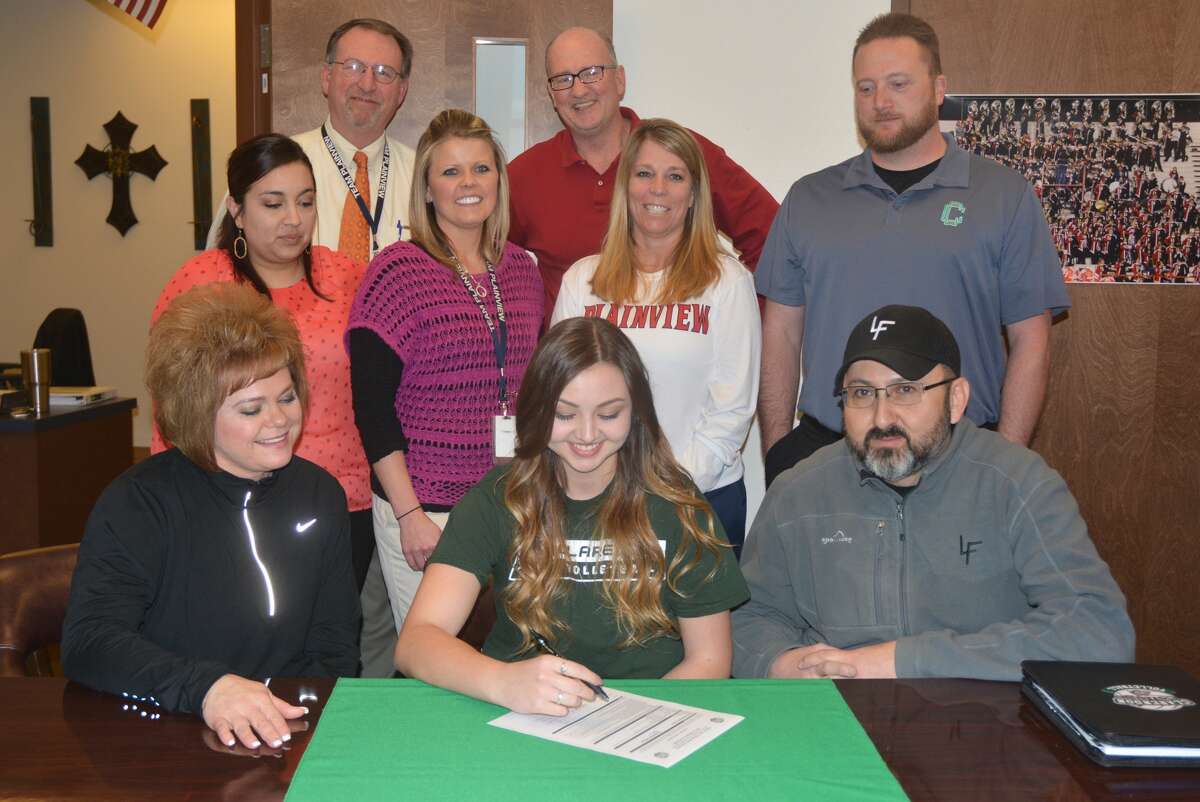 Plainview High School senior Taryn Garza, seated center, signs a letter of intent to play volleyball at Clarendon College. Flanking her are her mom Noelle, left, and her dad Homer, right. Standing in the second row are, from left, Plainview assistant volleyball coach Amanda Martin, Plainview assistant volleyball coach Shelly Faught, Plainview head volleyball coach Torri Hatch, and Clarendon College assistant volleyball coach Josh Branan. Standing third row, from left, are Plainview High School principal Brandt Reagan and Plainview ISD girls’ athletic director Danny Wrenn.