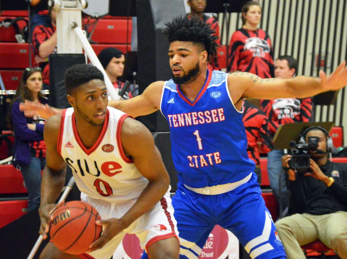 SIUE’s Carlos Anderson, left, looks to pass the ball to a teammate from underneath the basket against Tennessee State during first-half action Wednesday inside the Vadalabene Center.