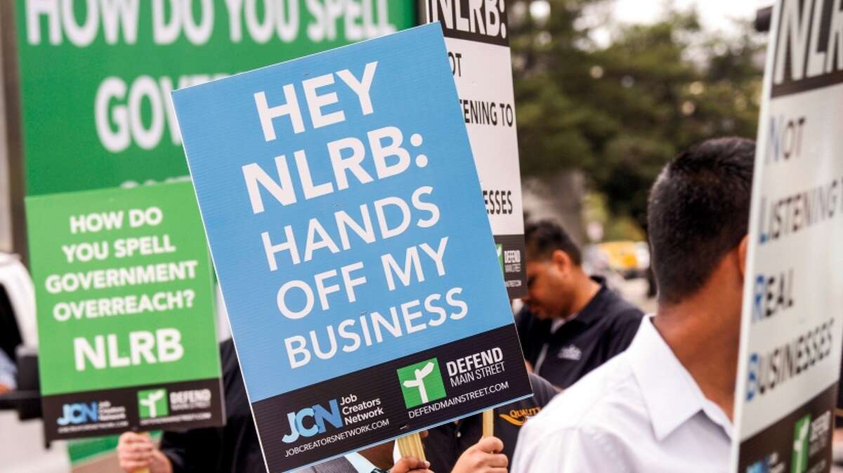 Small-business advocates defend the franchise system outside the National Labor Relations Board office in Tampa, Fla.