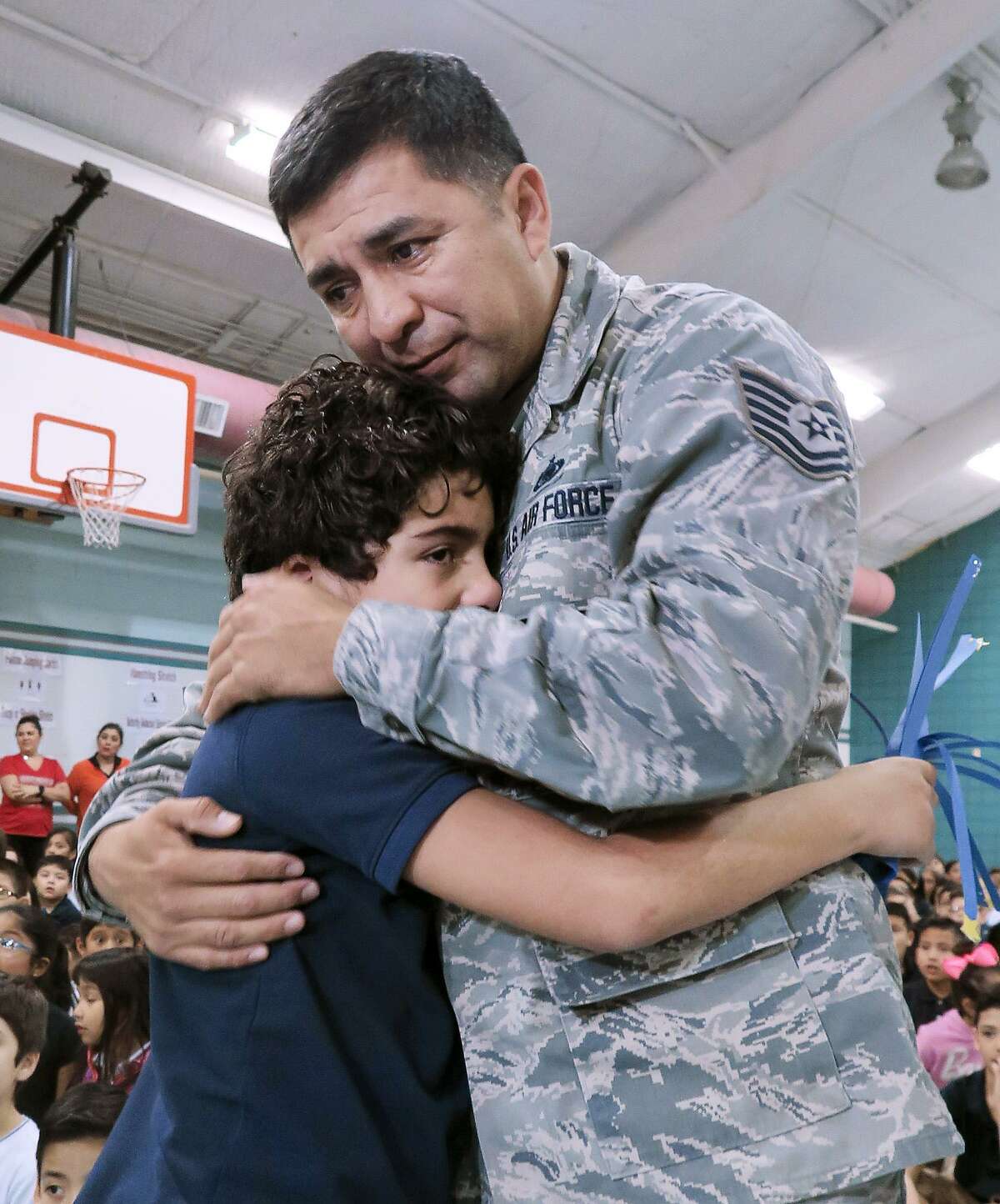 Muller Elementary student Alveyen Alfaro is embraced by his father, Air Force Sgt. Jose Alfaro, on Wednesday, Jan. 25, 2017, at the school gymnasium where Alfaro made a surprise entrance for his son after a seven-month military deployment.