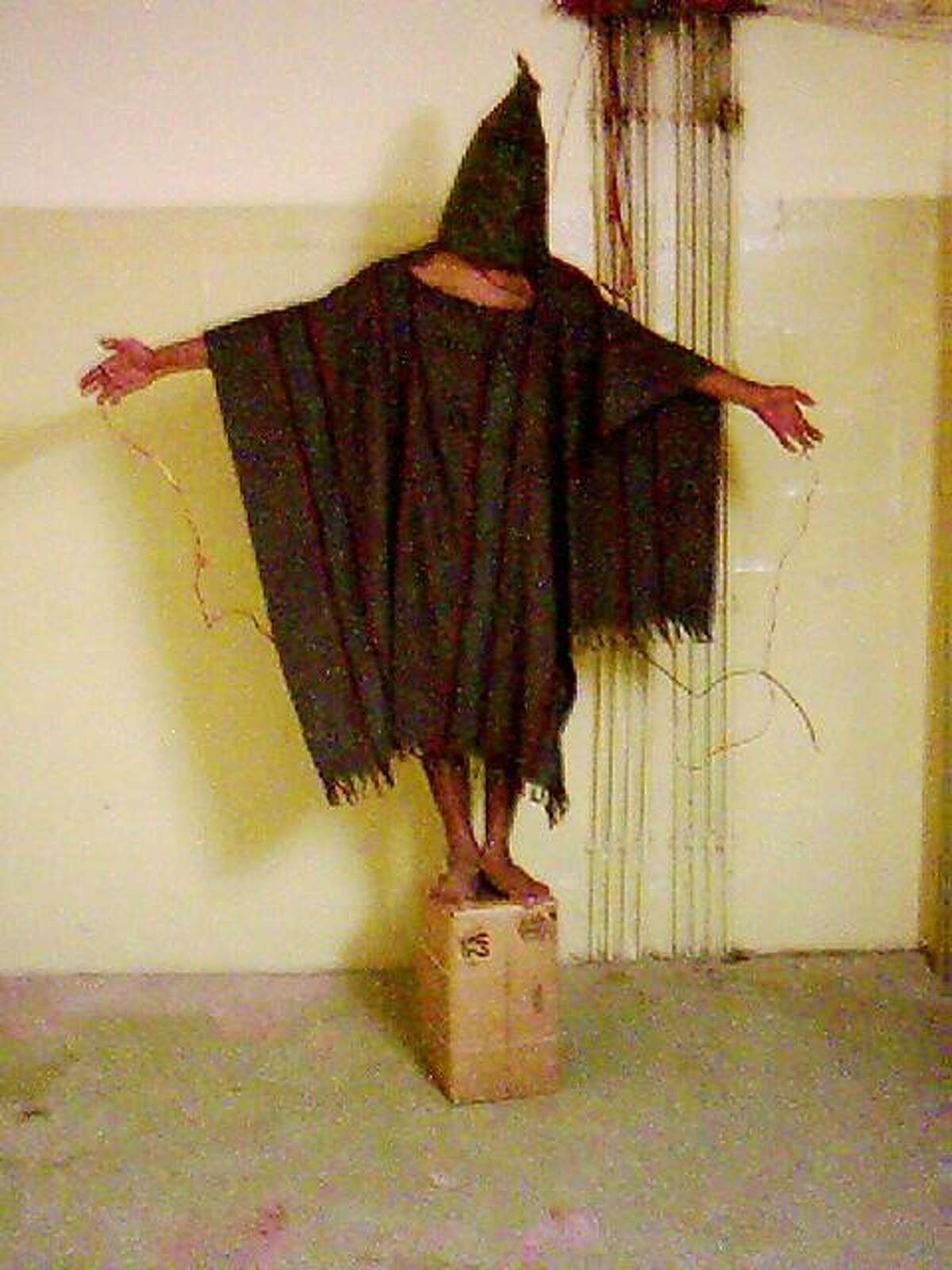 ** HOLD FOR RELEASE UNTIL 12:01 a.m. EDT, WEDNESDAY, JUNE 18, 2008 ** ** FILE ** This is a file image obtained by The Associated Press which shows an unidentified detainee standing on a box with a bag on his head and wires attached to him in late 2003 at the Abu Ghraib prison in Baghdad, Iraq. Years after being released by the U.S. military, former detainees held in Abu Ghraib and Guantanamo Bay Naval Base are suffering debilitating injuries and mental disorders from their interrogation and alleged torture, according to a new report by a human rights group. (AP Photo)
