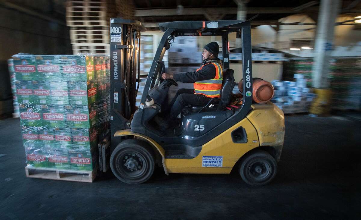 Erasmo Barrera, an employee for Impact Transload and Rail, moves a pallet of beer at the Port of Oakland on January 26, 2017. The port is trying to convince shipping companies arriving from Asia to first visit its facility as a way to boost import business.