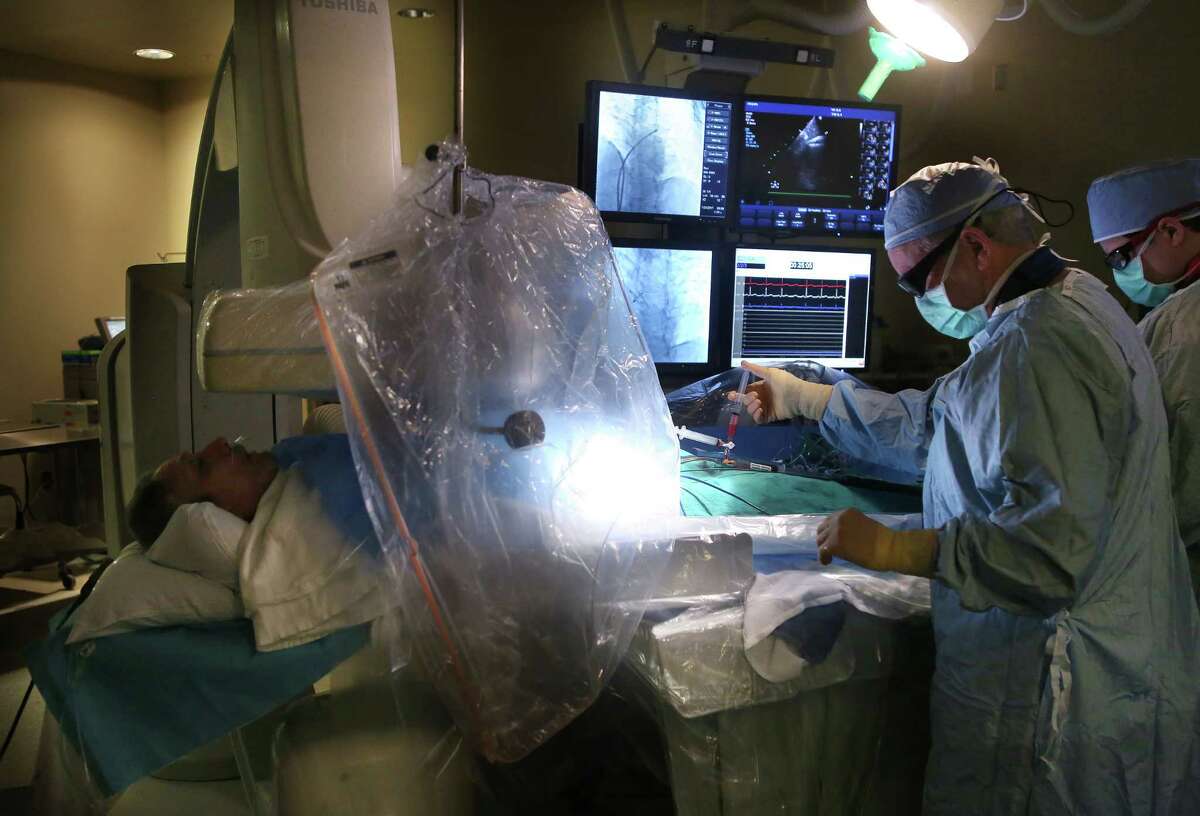 Dr. Richard Smalling (right) can speak with Arturo Garza (left) while working on his heart Tuesday, Jan. 24, 2017, at Memorial Hermann Heart & Vascular Institute in Houston. Garza has suffered strokes in the past and a new study shows that implantation of the device should prevent ones in the future. The device can be installed through a catheter going from the groin area to the heart.