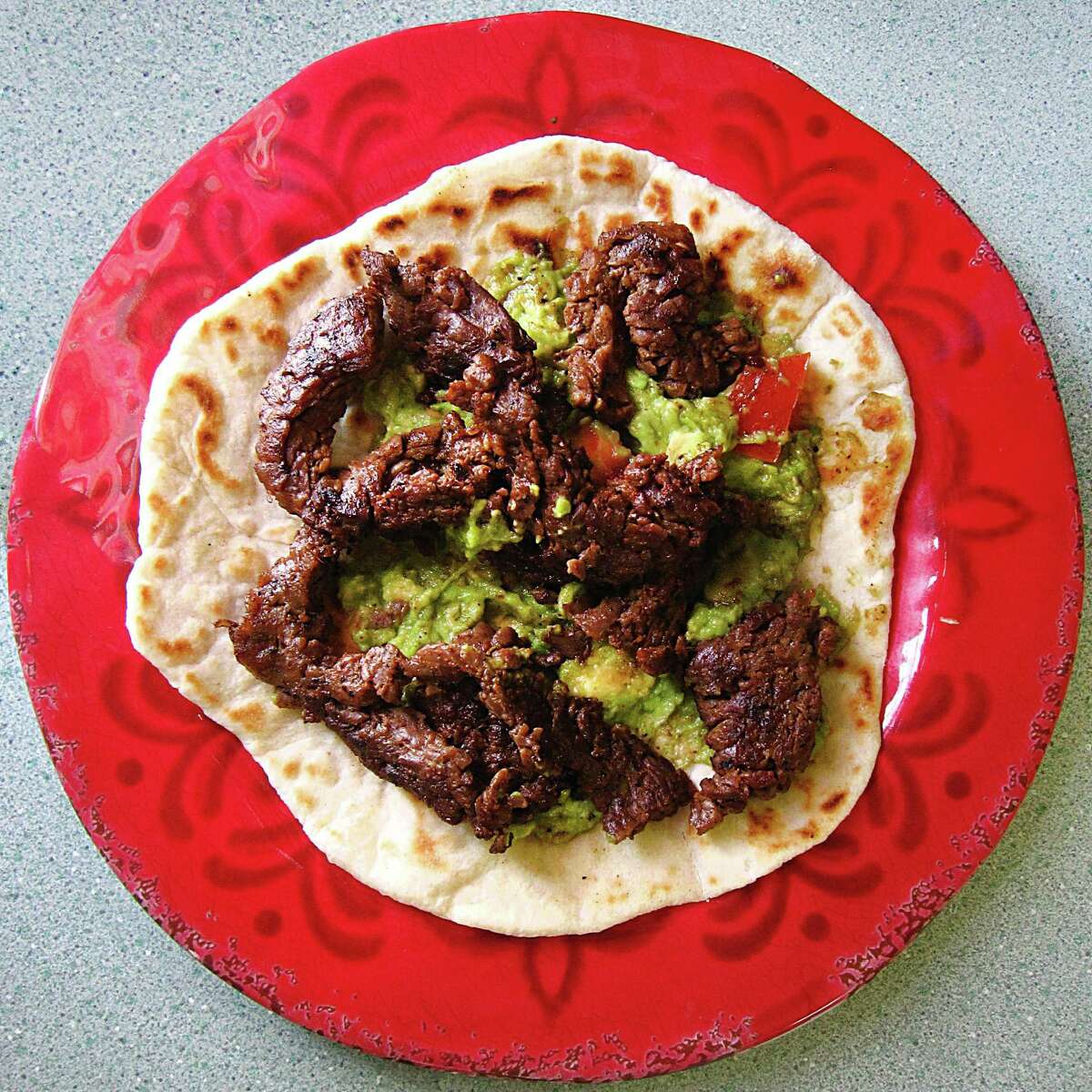 Beef fajita taco with guacamole on a handmade flour tortilla from Mendez Cafe.