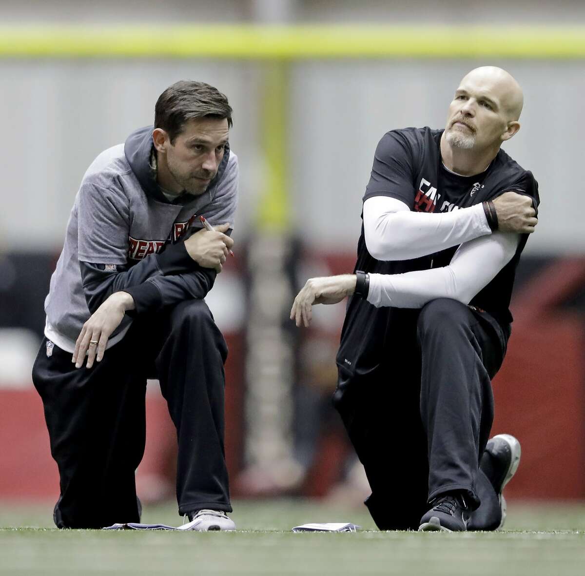 Atlanta Falcons head coach Dan Quinn, right, talks with offensive coordinator Kyle Shanahan during a workout at the NFL football team's practice facility in Flowery Branch, Ga., Friday, Jan. 27, 2017. (AP Photo/David Goldman)