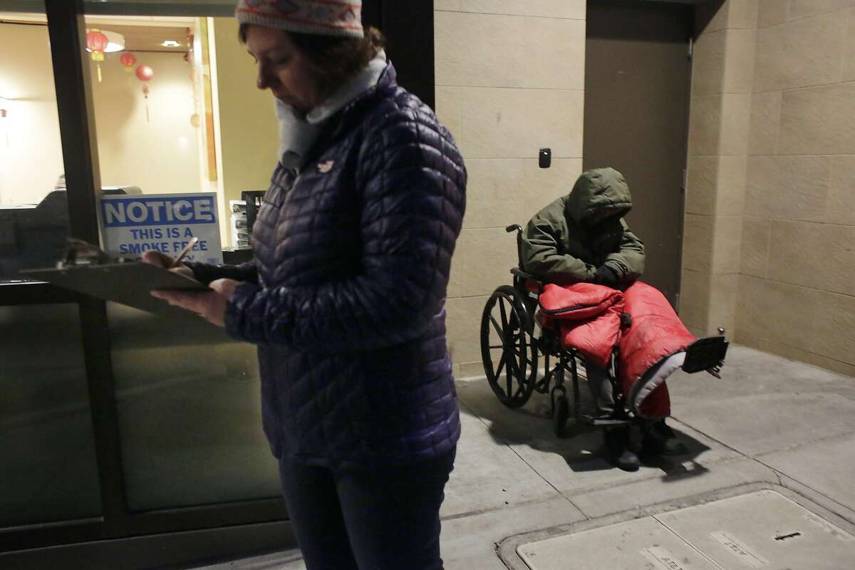 Gigi Whitley, (l to r)�Department of Homelessness and Supportive Housing�deputy director of administration and finance,��marks the tally sheet during the Homeless Point-in-Time Count as Gregory Clark sits in a wheelchair on the street on Thursday, January 26, 2017 in San Francisco, Calif.