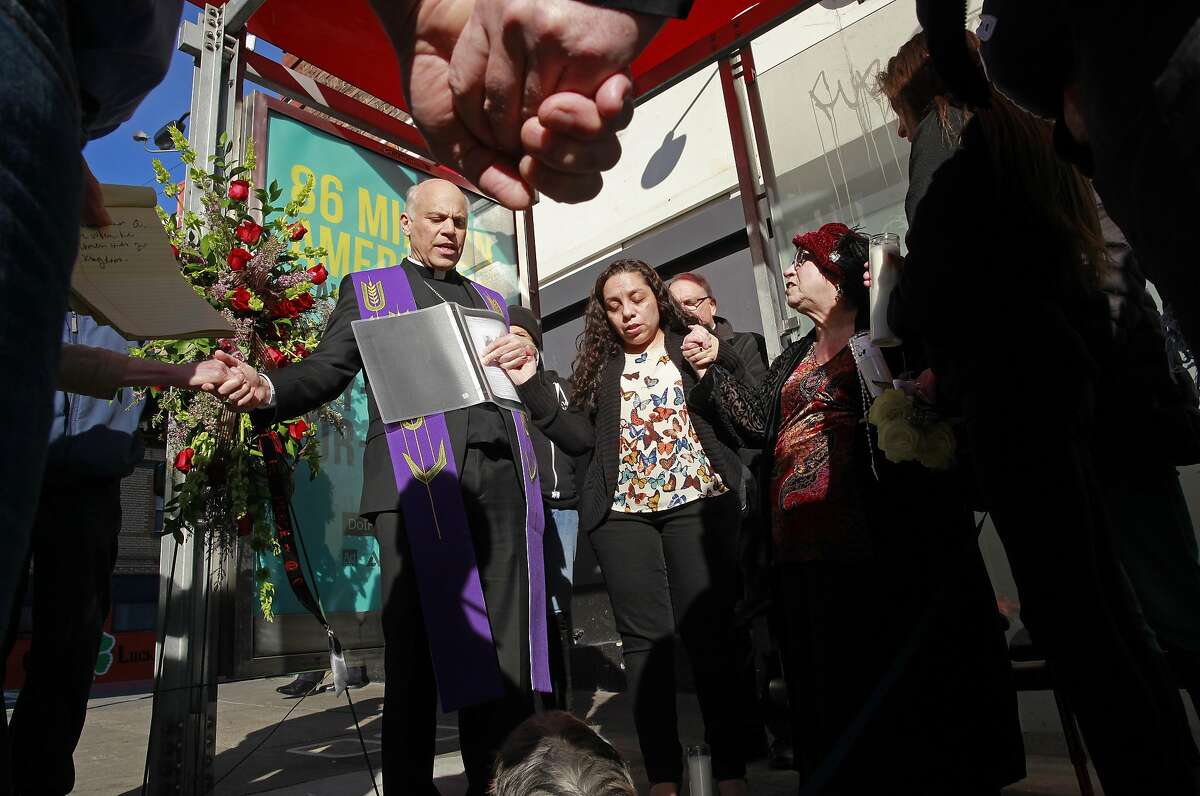 The Archbishop of San Francisco Salvatore Cordileone leads a prayer service on the corner of O' Farrell and Larkin streets, for Gabriel Ramirez, joined by Alma Zamora the Restorative Justice Community Organizer for the Archdiocese of San Francisco (to his left) and the girlfriend of the victim Grainne O'Brien (right center red hat) in San Francisco, Ca., on Friday Jan. 27, 2017. Ramirez, 61 years old, was beaten and killed in the Tenderloin on January 5th.