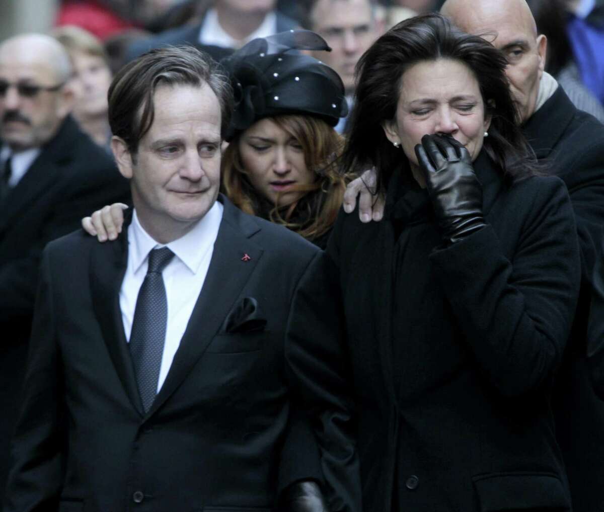 Matthew Badger, left, and Madonna Badger, the parents of three children that were killed in a fire, react as their caskets are carried into a church during the funeral in New York, Thursday, Jan. 5, 2012. Hundreds of people streamed into a historic church in the heart of Manhattan on Thursday for the funeral of three young girls who died along with their grandparents during a Christmas morning fire in Stamford, Conn. (AP Photo/Seth Wenig)