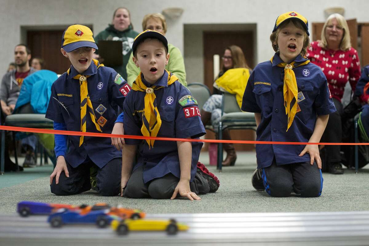 From left, Cub Scout Derek Riter, 8, Wolf Scout Hayden Haller, 8, and Wolf Scout Joshua Ross, 8, watch pinewood derby cars race down the track during one of the heats on Friday at Trinity Lutheran Church. Adams Elementary Boy Scout Troop 3722 raced their pinewood derby cars, while the girl scouts will race them at the church on Saturday.
