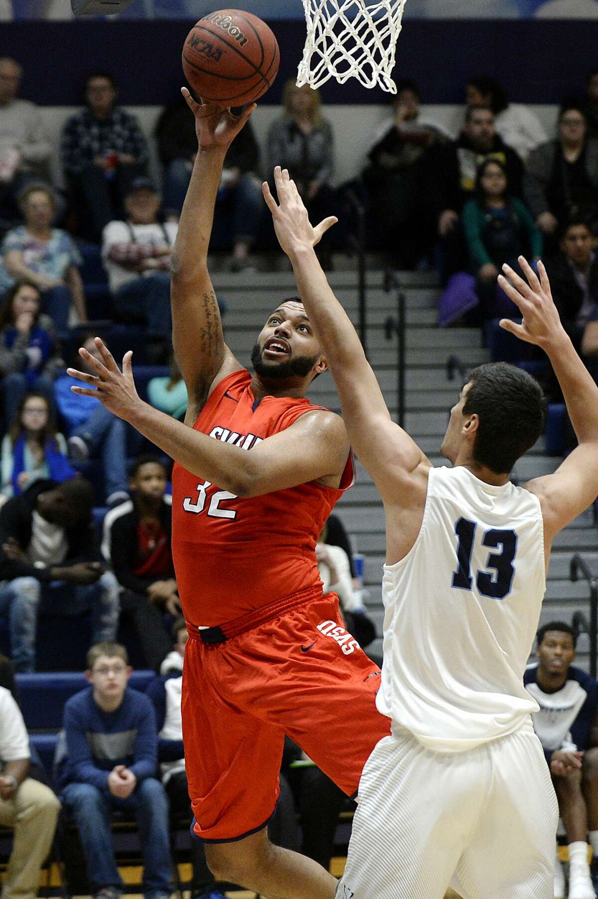 Saginaw Valley State's Devin Dixon, left, shoots as Northwood's David Jelinek defends during the first half on Saturday at Riepma Arena on the NU campus. Northwood won 64-63.