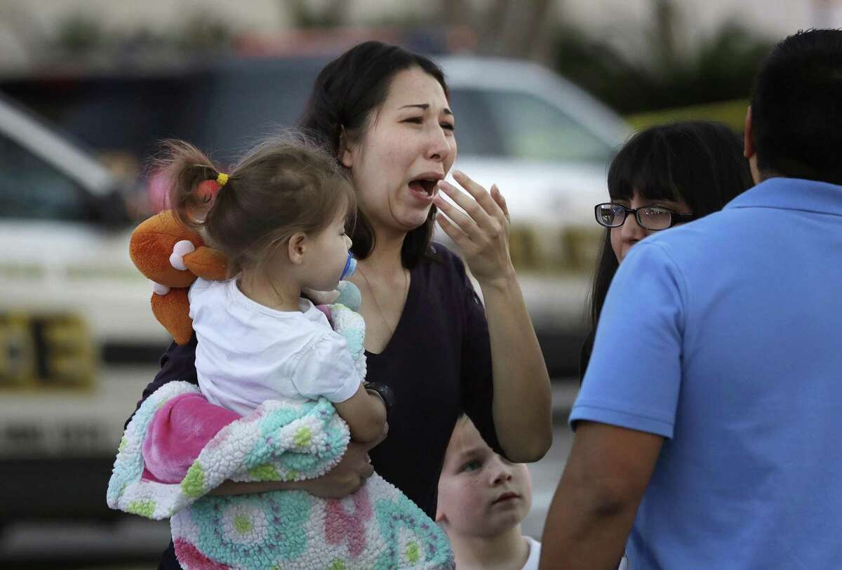 A woman holds her child after San Antonio police helped her and other shoppers exit the Rolling Oaks Mall, Sunday, Jan. 22, 2017, in San Antonio, after a deadly shooting. Retail analysts say malls and shopping centers aren’t impacted in the long-term by violent events.