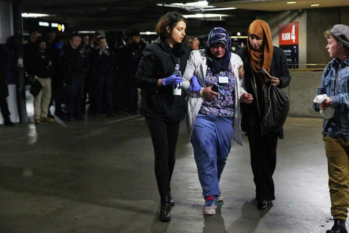 CORRECTION: An earlier version of this collection misidentified the department of the police officers pictured. Officers from 11 departments responded to the Sea-Tac Airport protest. Saffiya Hrahsheh, center, is helped away from police by Liz Bates, left, and others after being pepper sprayed as police made their final dispersal of protesters out to the parking garage. More than 1,000 people gather at Seattle-Tacoma International Airport, Saturday, January 28 to protest President Trump's immigration ban. President Trump signed an executive order Friday that bars citizens from Iraq, Syria, Iran, Libya, Somalia, Sudan and Yemen from entering the U.S. for the next 90 days and suspends the admission of all refugees for 120 days.