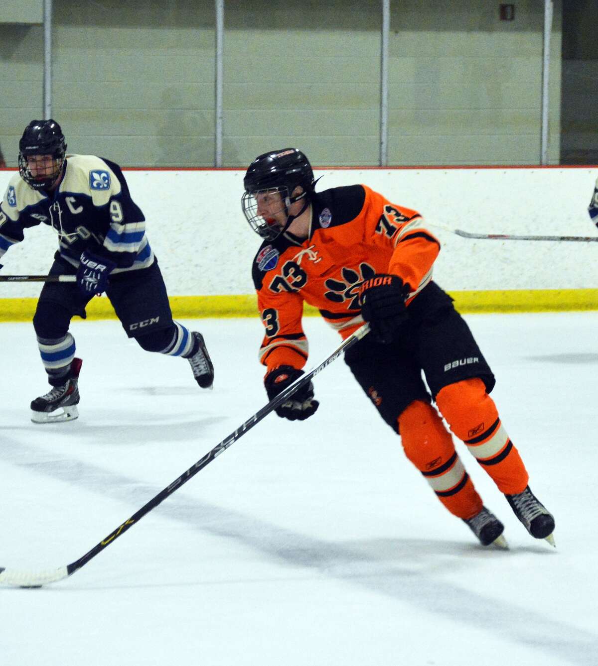 Edwardsville’s Lucas Tucker, right, carries the puck over the blue line in the second period.