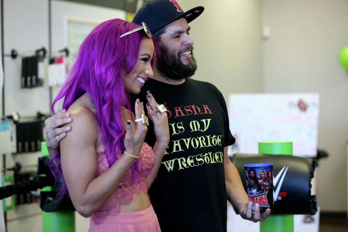 Louis Dominguez, 36, gets his photo taken with World Wrestling Entertainment Superstar Sasha Banks as she draws a large crowd as she signs autographs and poses for pictures at a Cricket Wireless store on SE Military Drive, Sunday, Jan. 29, 2017. Organizers were expected she would get to 850-900 people during the two-hour session.