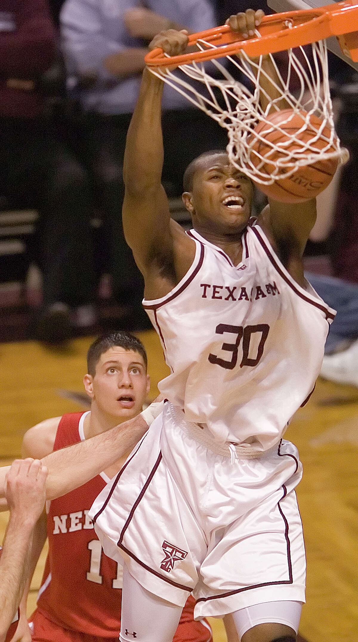 Texas A&M's Joseph Jones dunks in front of Nebraska's Wes Wilkinson during the second half of a college basketball game Saturday, Feb. 25, 2006, in College Station, Texas. Texas A&M won 66-55. (AP Photo/Bryan-College Station Eagle, Butch Ireland)
