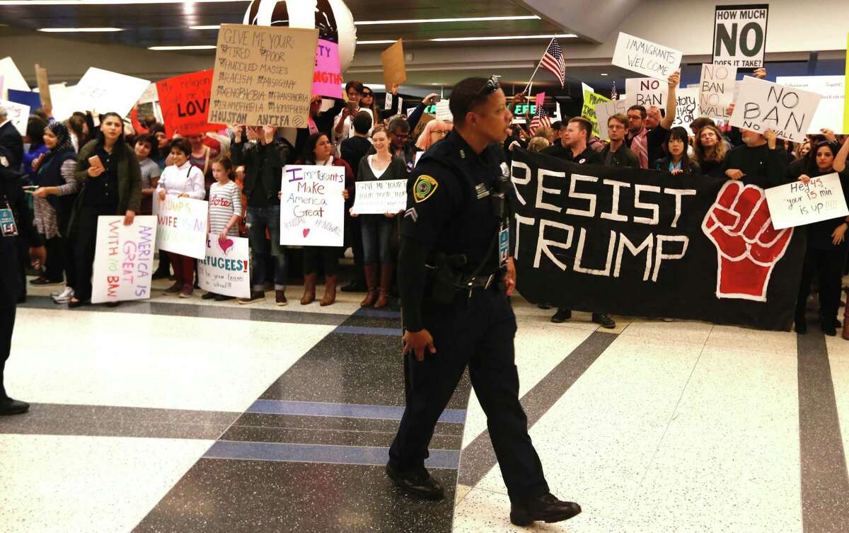 Demonstrators protest anti-immigrant policies and a Muslim travel ban instituted via executive order by the Trump administration as they fill the international arrivals area at George Bush Intercontinental Airport on Sunday.