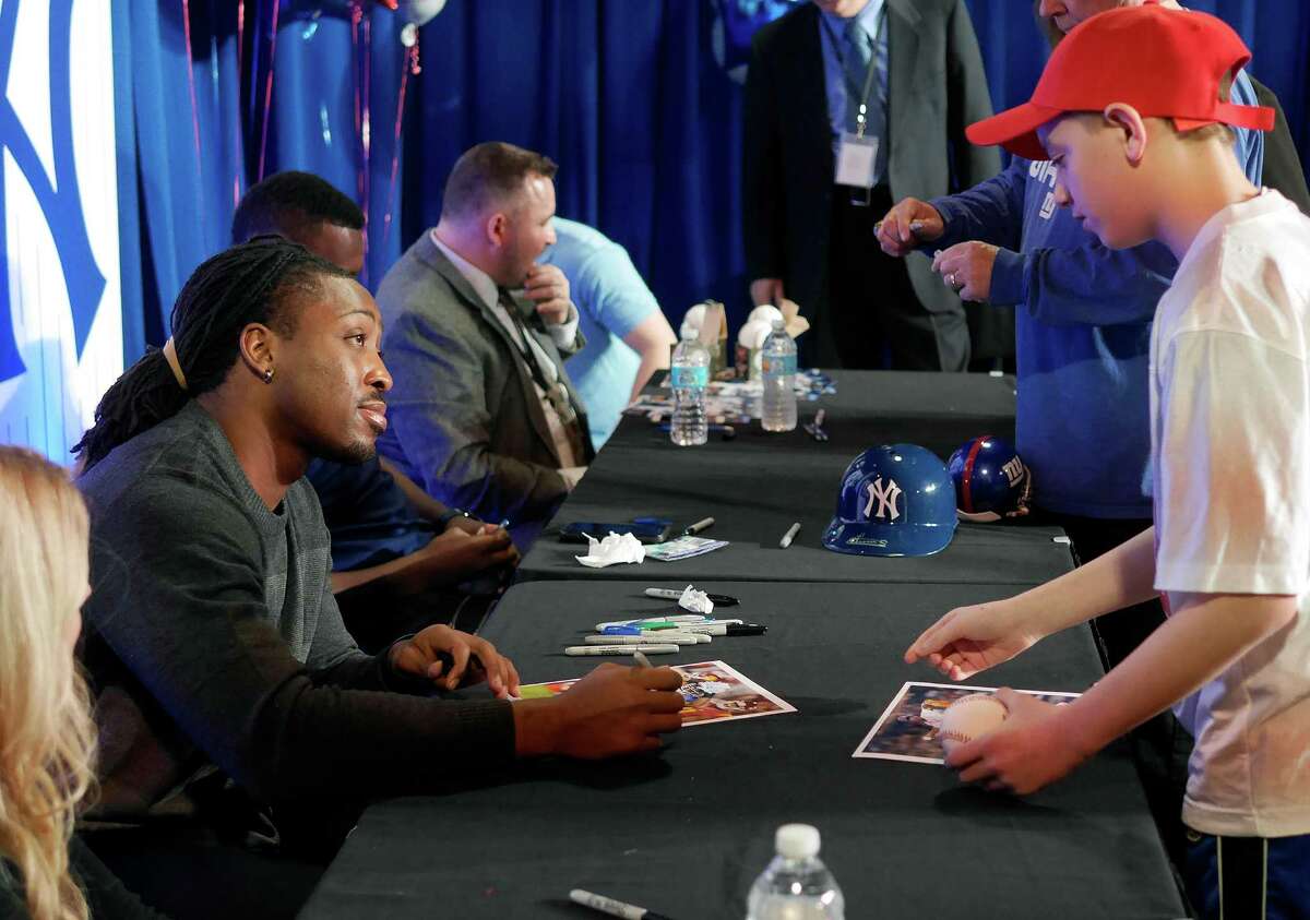 Paul Perkins, left, a running back for the New York Giants, talks with a fan at the #518Gives Telethon to benefit the Center for Disability Services on Sunday, Jan. 29, 2017, in Albany, N.Y. (Paul Buckowski / Times Union)