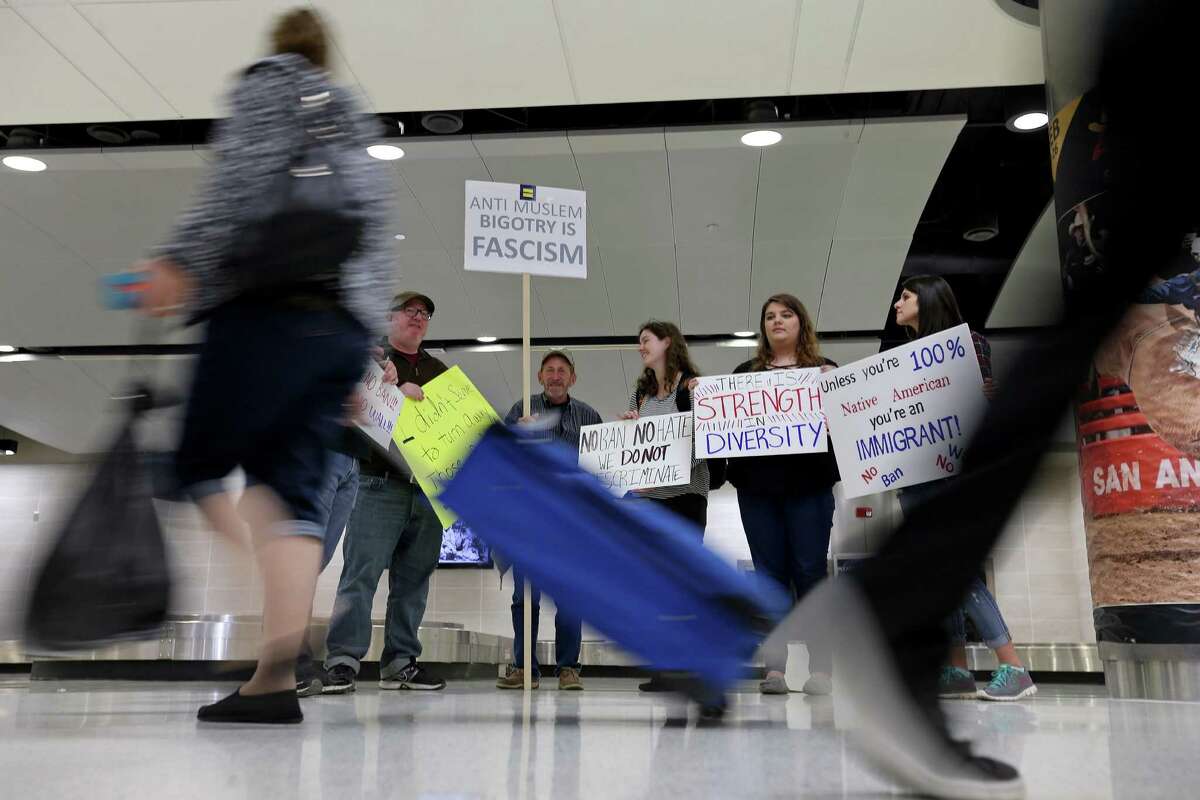 Protesters hold signs in the Terminal A baggage claim at the San Antonio International Airport Sunday Jan. 29, 2017. The group was protesting recent executive order signed by President Donald Trump that temporarily bans people from several Muslim majority countries from entering the United States.
