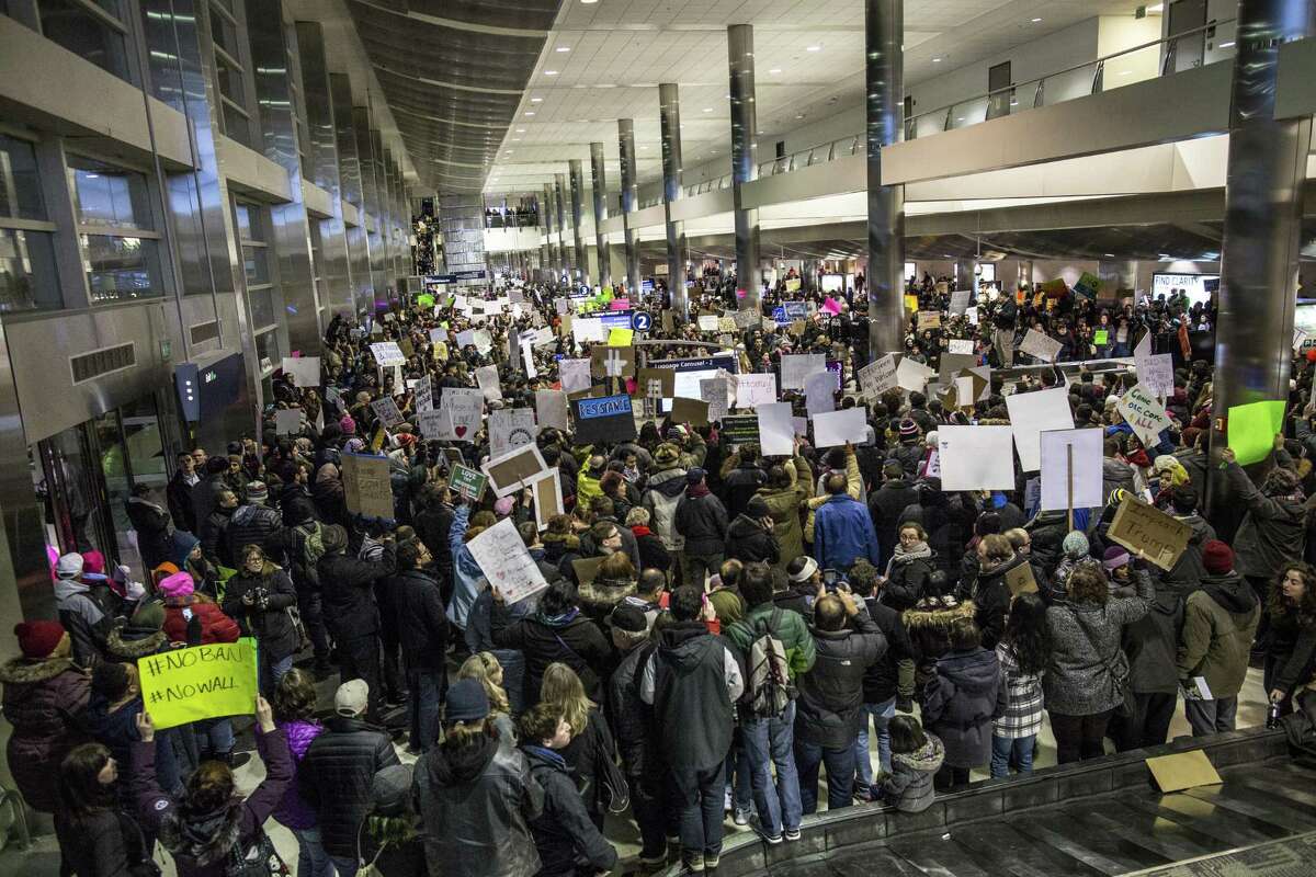 Demonstrators gather in the baggage claim area during a protest against President Donald Trump’s executive order banning travel to the United States by citizens of several countries Sunday at Detroit Metropolitan Airport.