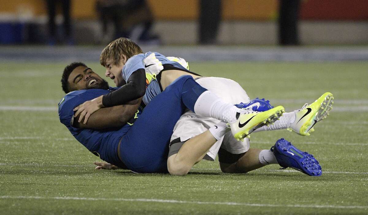 NFC running back Ezekiel Elliot of the Dallas Cowboys, tackles a man that ran on the field, during the second half of the NFL Pro Bowl football game Sunday, Jan. 29, 2017, in Orlando, Fla. (AP Photo/Phelan M Ebenhack)