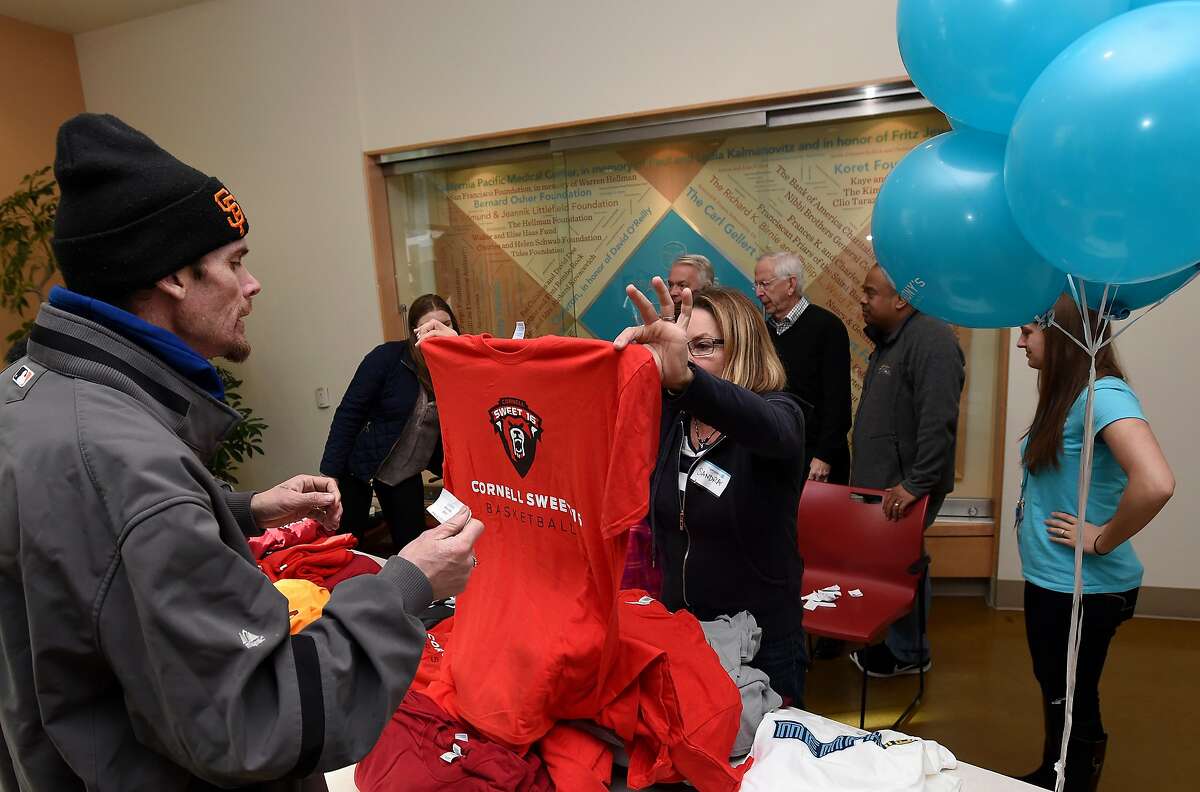 A man who declined to give his name collects a free shirt as part of the annual One Warm Shirt donation drive at the St. Anthony Foundation in San Francisco on January 30, 2017. Hundreds of items including t-shirts and sweatshirts were given away to anyone in need.