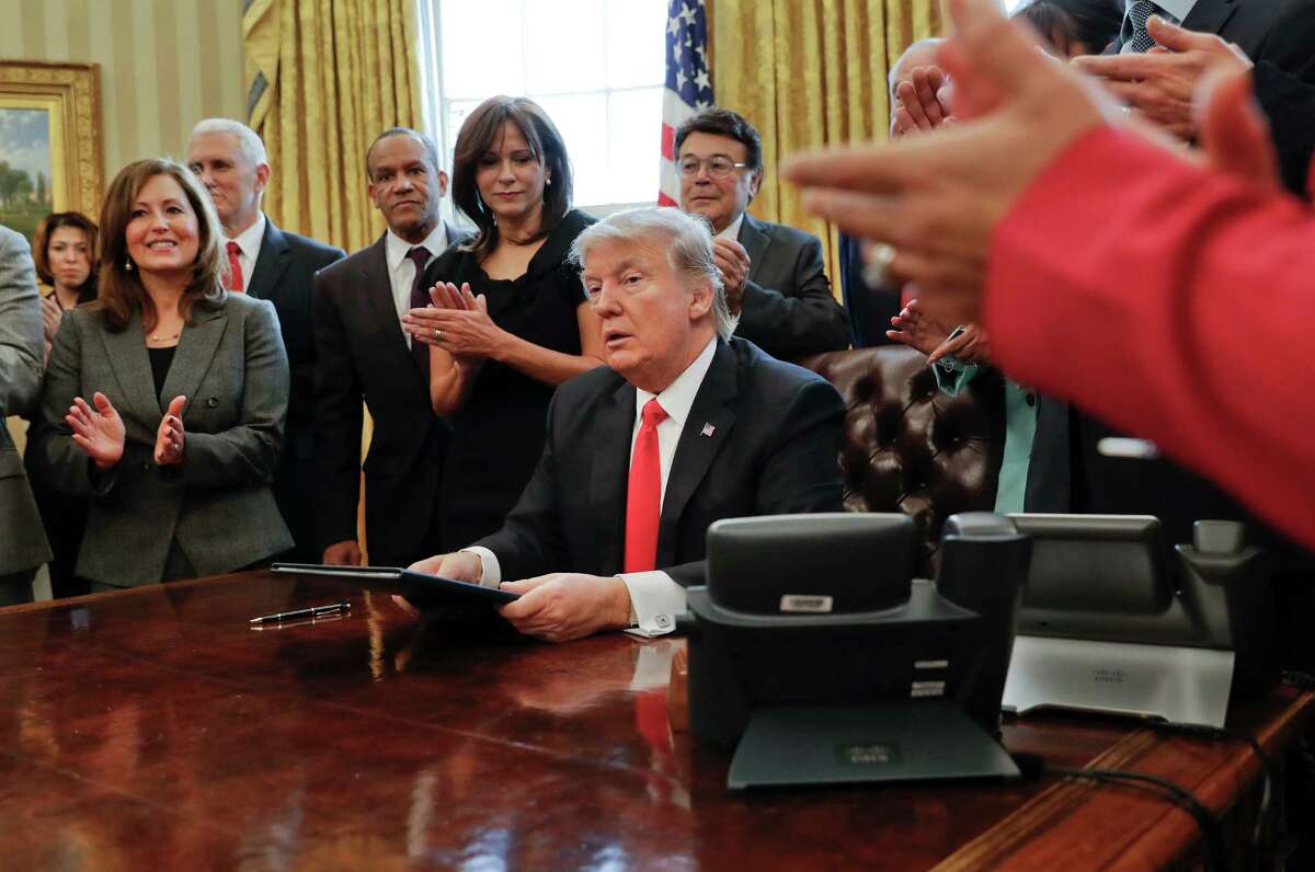 Small business leaders applaud President Donald Trump after he signed an executive order in the Oval Office of the White House in Washington, Monday, Jan. 30, 2017. Trump order is aimed at significantly cutting regulations. White House officials are calling the directive a "one in, two out" plan. It requires government agencies requesting a new regulations to identify two regulations they will cut from their own departments. (AP Photo/Pablo Martinez Monsivais)