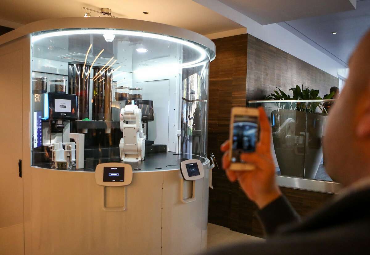 Emil Michael takes photos of the robotic arm at Cafe X, the first robotic cafe, located within the Metreon in San Francisco, Calif. on Monday, January 30, 2017.