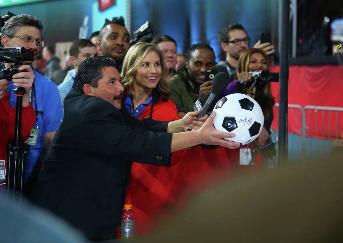 Guillermo Rodriguez from the Jimmy Kimmel Show asks Julio Jones to sign his soccer ball during Super Bowl Opening Night at Minute Maid Park, Monday, Jan. 30, 2017, in Houston.