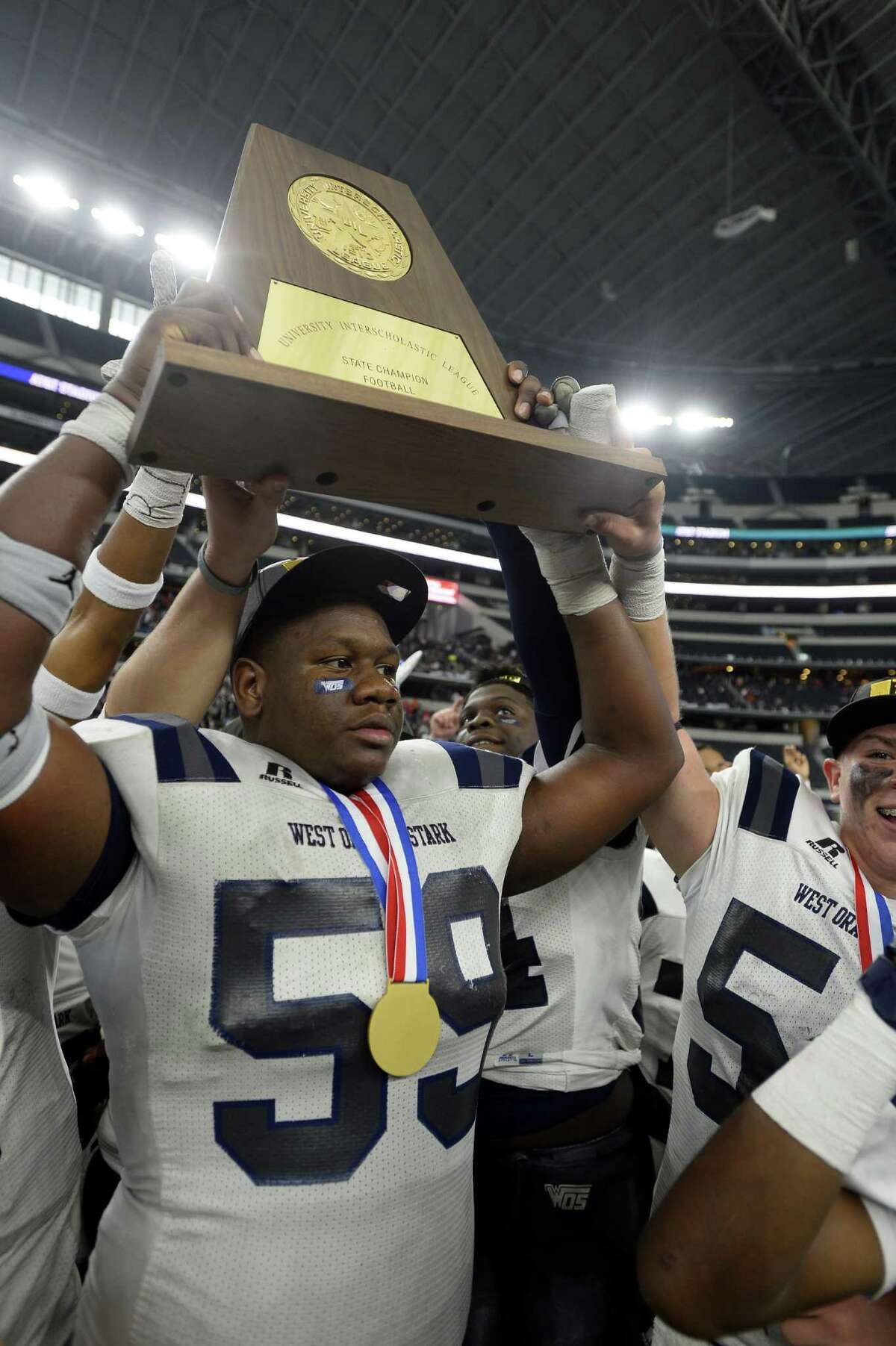West Orange-Stark’s Morris Joseph hoists the trophy after beating Sweetwater in the Class 4A Division II state final at AT&T Stadium in Arlington on Dec. 16, 2016.
