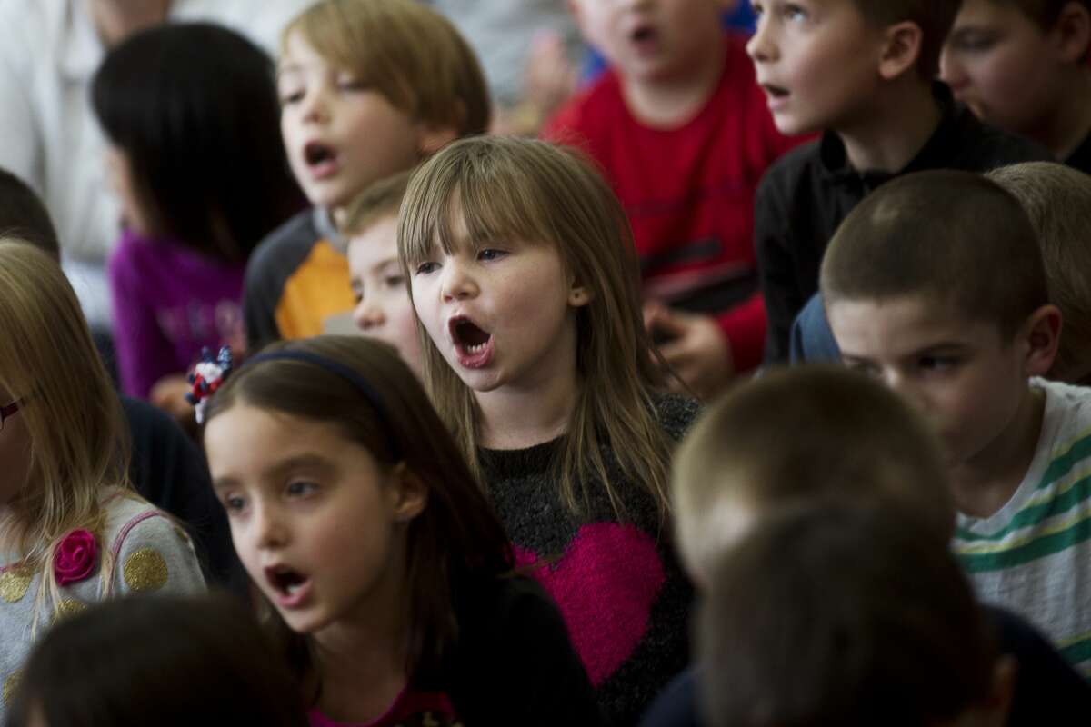 Carpenter Street kindergartner Aleigh Sanders, 5, sings the school song on Tuesday at Carpenter Street School. The school celebrated its 90th birthday on Tuesday afternoon with songs, treats and words from Principal Jeffrey Lauer and alumni Michigan Attorney General Bill Schuette and his wife Cynthia Grebe. Starting with the 2017-18 school year, Carpenter Street and Eastlawn elementary schools will combine under the roof of the new Central Park Elementary School which will have a STEM focus.