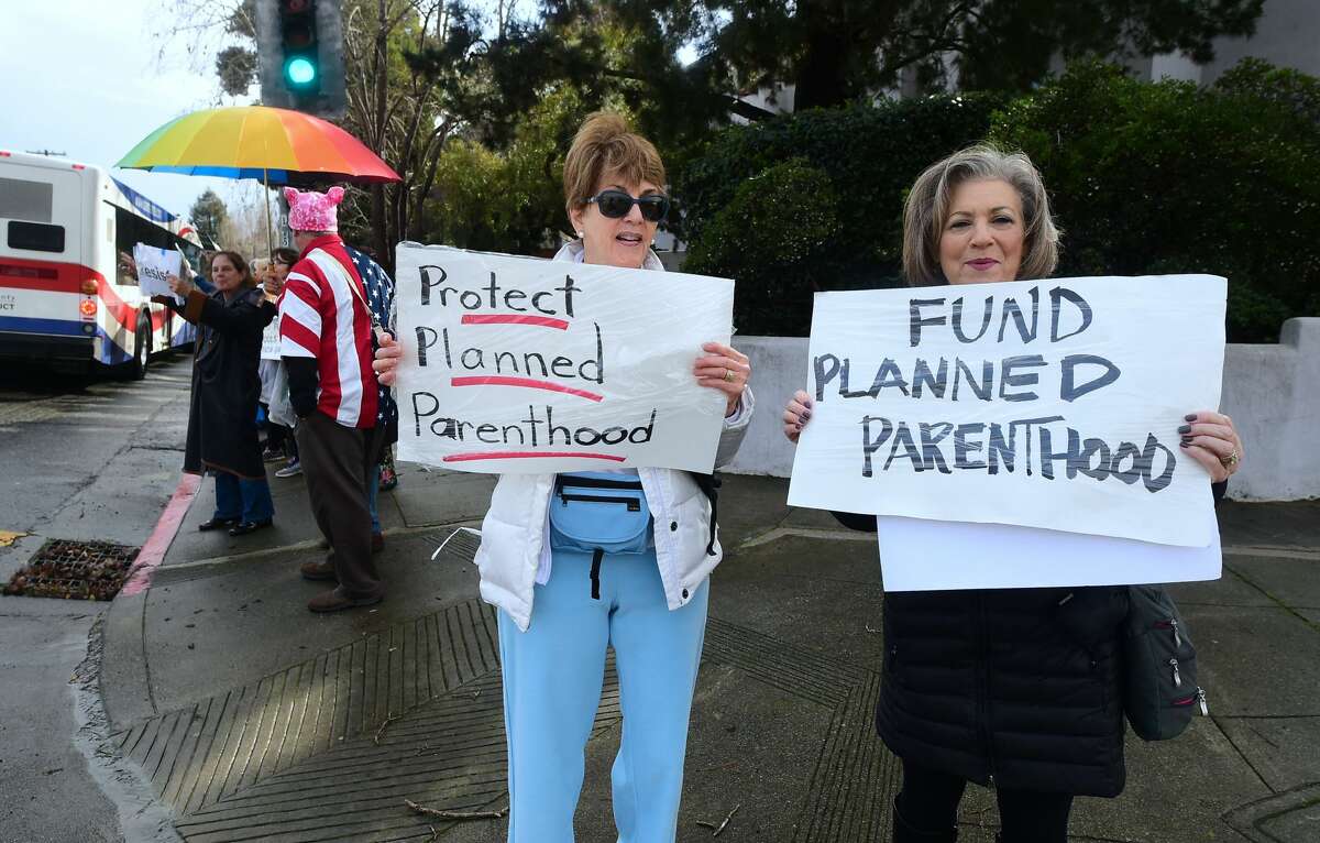 Esther Harris (L) and Rosalie Emanuel (R) hold placards showing support for Planned Parenthood joining demonstrators gathered along El Camino Real in San Mateo, California, in exercising their right to peaceful protest on Inauguration Day on January 20, 2017, following the swearing in of Donald Trump as the 45h President of the United States. / AFP / Frederic J. BROWN (Photo credit should read FREDERIC J. BROWN/AFP/Getty Images)