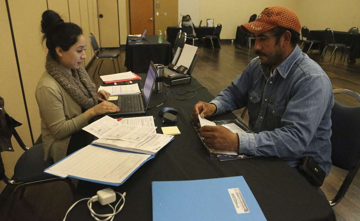 Jeanette Perez (left) helps Manuel Hernandez (right) go through the health insurance application process Tuesday January 31, 2017 at CentroMed on San Antonio's South Side. Tuesday January 31, 2017 is the last day for people to sign up for the Affordable Care Act.