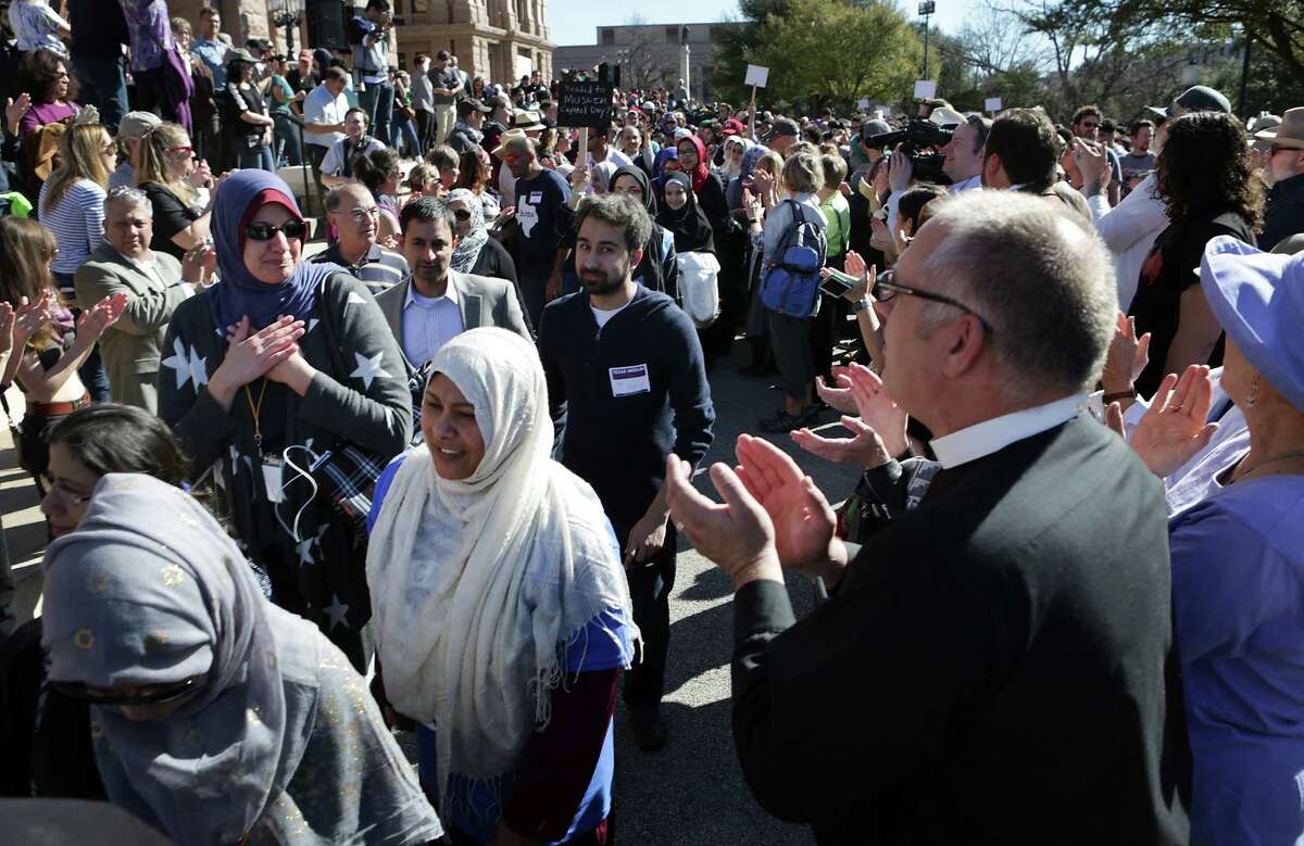 Pastor Brad Fuerst, right, of the Lutheran Campus Ministry at UT, and others applaud some of the 800 Muslims as they walk to the First United Methodist Church where the group held meetings following the Muslim Capitol Day, in Austin, Texas on Tuesday, Jan. 31, 2017.