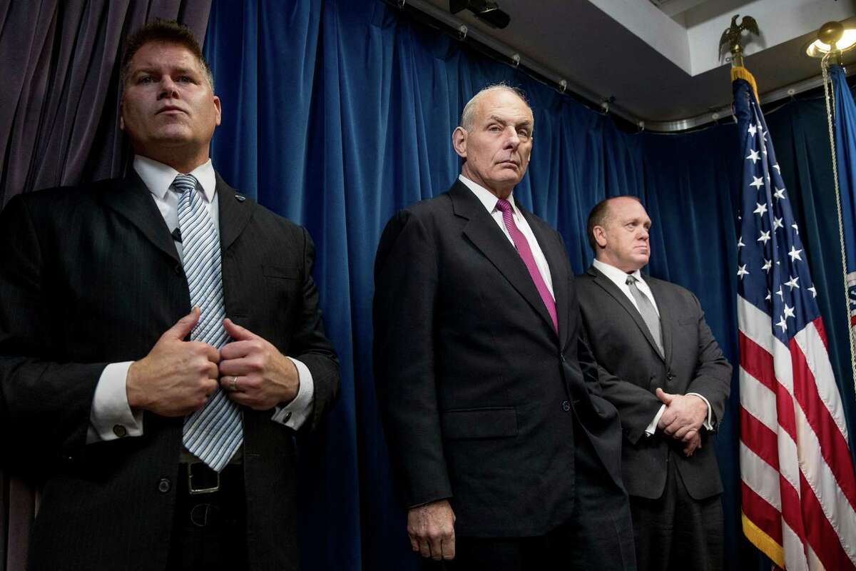 Homeland Security Secretary John Kelly, center, accompanied by U.S. Immigration and Customs Enforcement Acting Director Thomas Homan, right, and a member of his security detail, attends a news conference at the U.S. Customs and Border Protection headquarters in Washington, Tuesday, Jan. 31, 2017, to discuss the operational implementation of the president's executive orders. (AP Photo/Andrew Harnik)