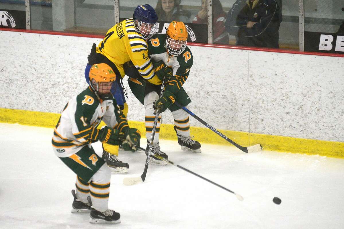 From left, Dow's Brendan Holbrook, Midland's Carson Kraenzlein and Dow's Nathan Painter fight for possession of the puck on Tuesday at the Midland Civic Arena.