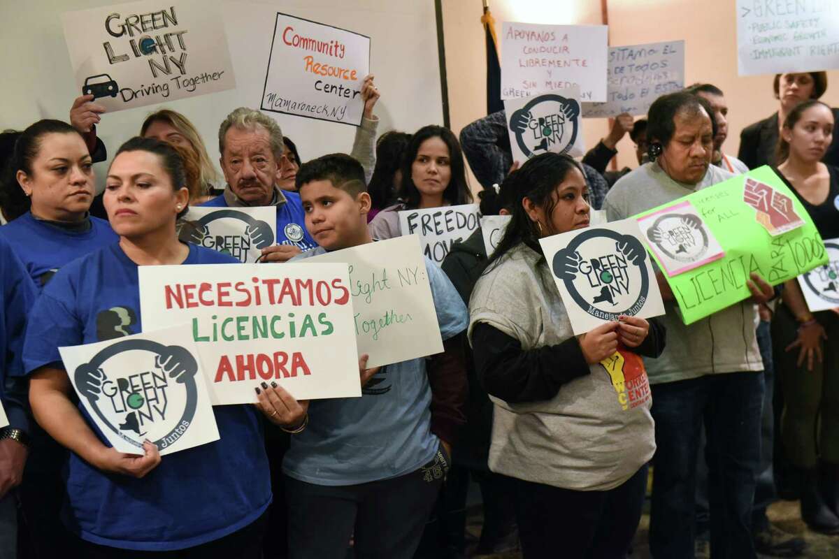 Undocumented immigrant workers stand with signs during a press conference to call for giving undocumented immigrants drivers licenses at the Empire State Plaza on Tuesday, Jan. 31, 2017 in Albany, N.Y. (Lori Van Buren / Times Union)