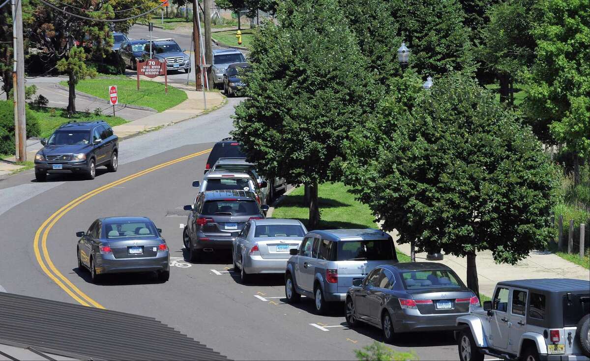 City officials believe that metered parking is necessary on Mill River Street, shown in this view taken from a room balcony at the Hampton Inn and Suites by Hilton that over looks Mill River Park in Stamford, Conn. on Aug. 4, 2016, to help drive turnover because too many people are parking long term in spots on the street. Currently there are no meters and along Mill River Street is restricted to two hours on one side of the street.