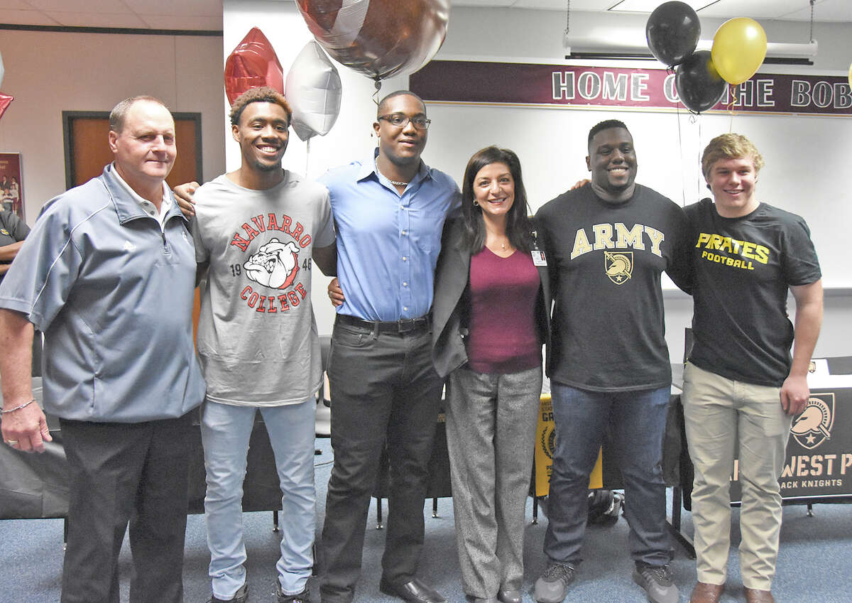 Cy-Fair High School National Signing Day signees celebrate in the school's ceremony Wednesday. Standing left to right are Cy-Fair Football Head Coach and Campus Athletic Coordinator Ed Pustejovsky, wide receiver B.J. Chambers (Navarro College), defensive lineman Arnold Crayton (Missouri Western State), Cy-Fair High School Principal Ana Martin, defensive lineman Hunter Adams (United States Military Academy - West Point) and linebacker Kyle Allison (Southwestern University).