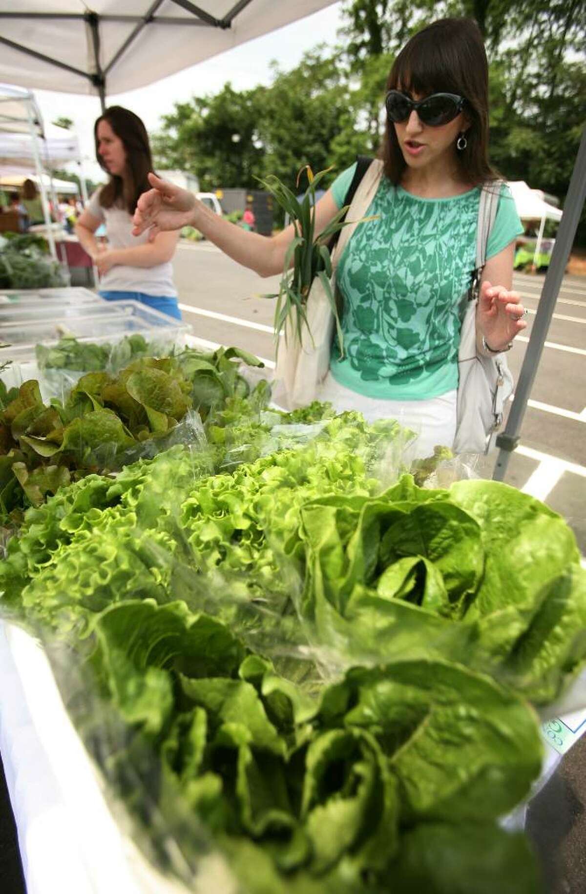 Analiese Paik, right, founder of the Fairfield Green Food Guide, shops for fresh locally grown produce at the Westport Farmers Market recently.